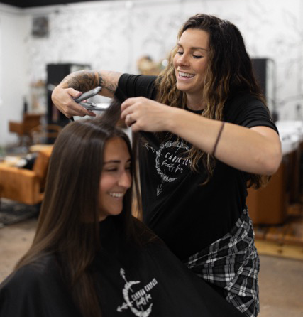 Photo of a stylist straightening a clients hair.