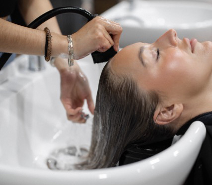 Photo of a client getting their hair washed in the salon.